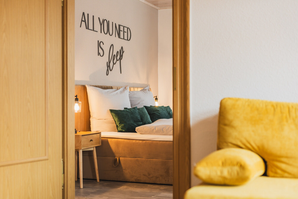 Schlafbereich der Ferienwohnung Casalotti mit gemütlichem Sessel