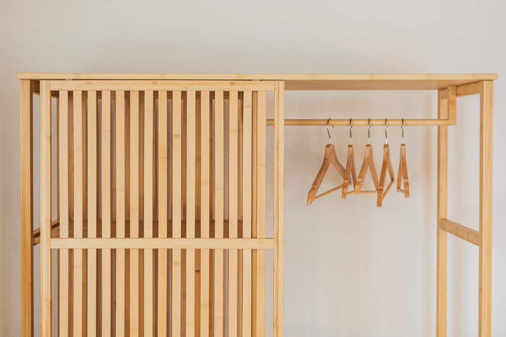 Offene Garderobe aus Holz mit Kleiderbügeln