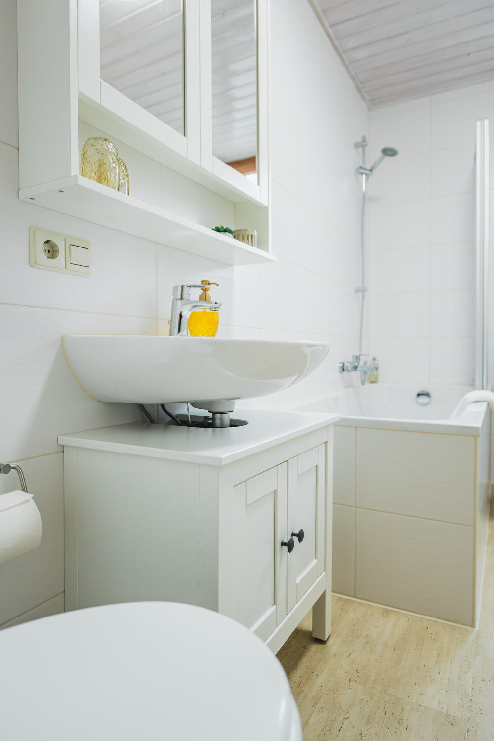 Helles Badezimmer mit Waschbecken und Spiegelschrank