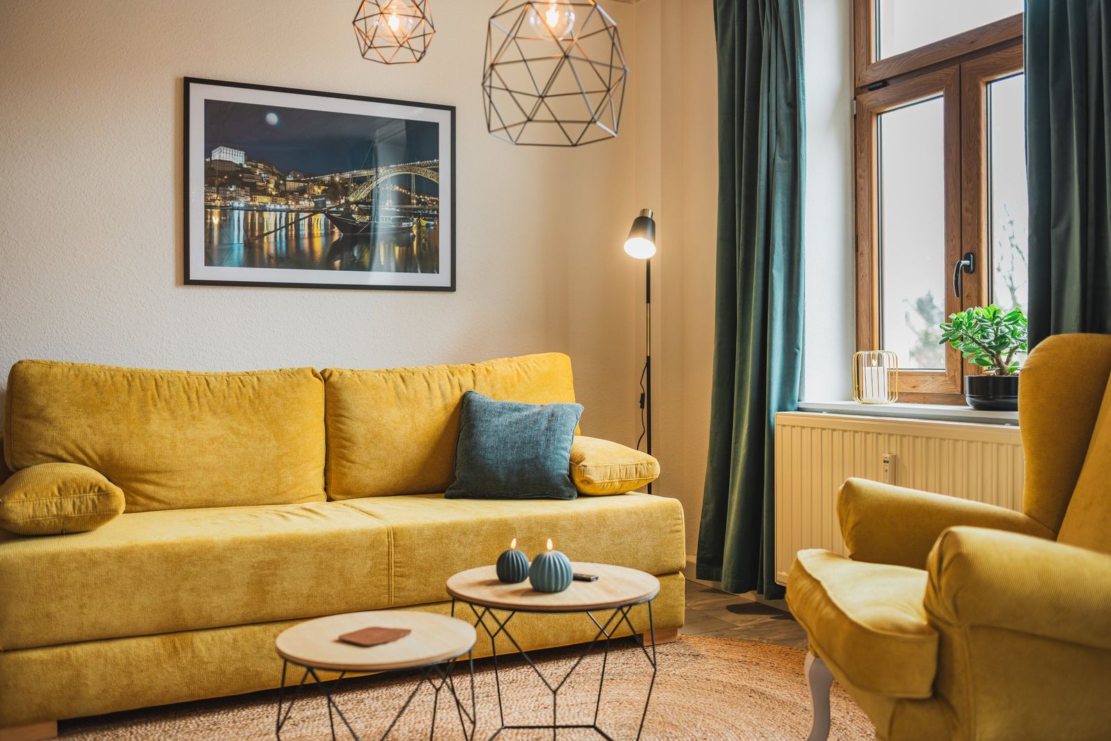 Gemütliches Wohnzimmer der Ferienwohnung Casalotti mit senffarbenem Sofa und Sessel