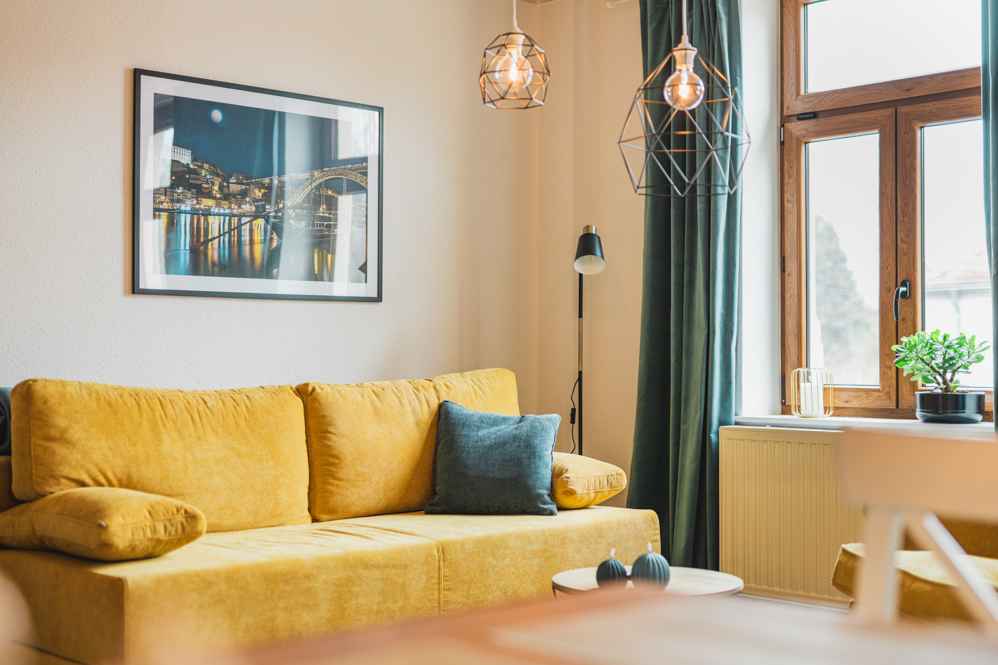 Wohnzimmer der Ferienwohnung Casalotti mit senffarbenem Sofa